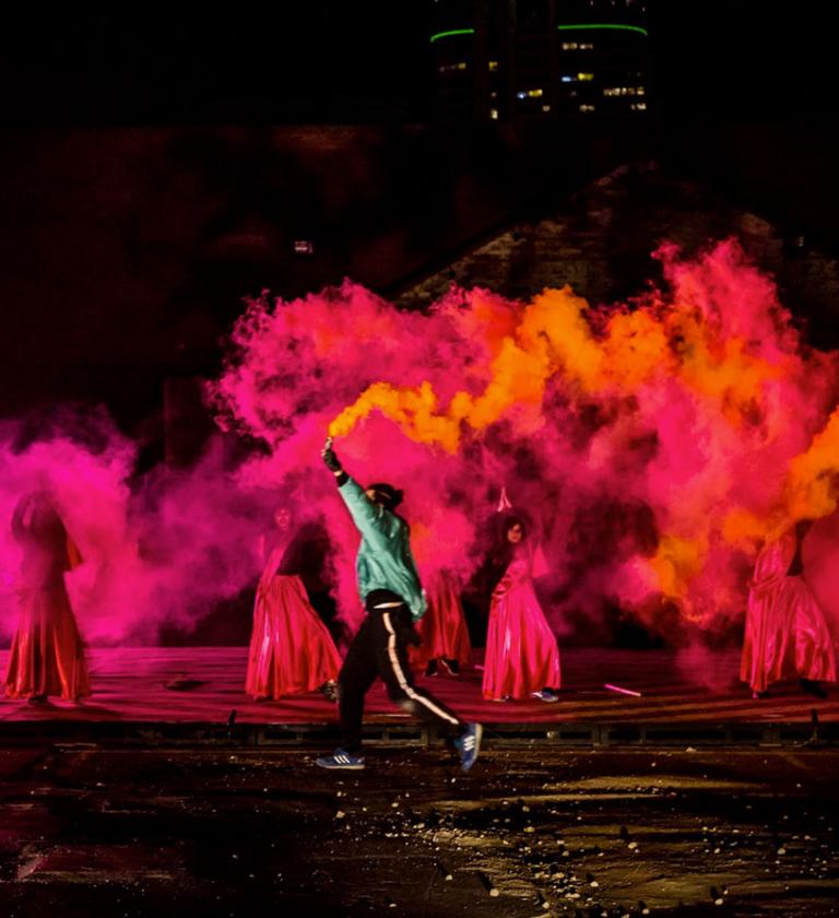 Performers using coloured smoke during performance