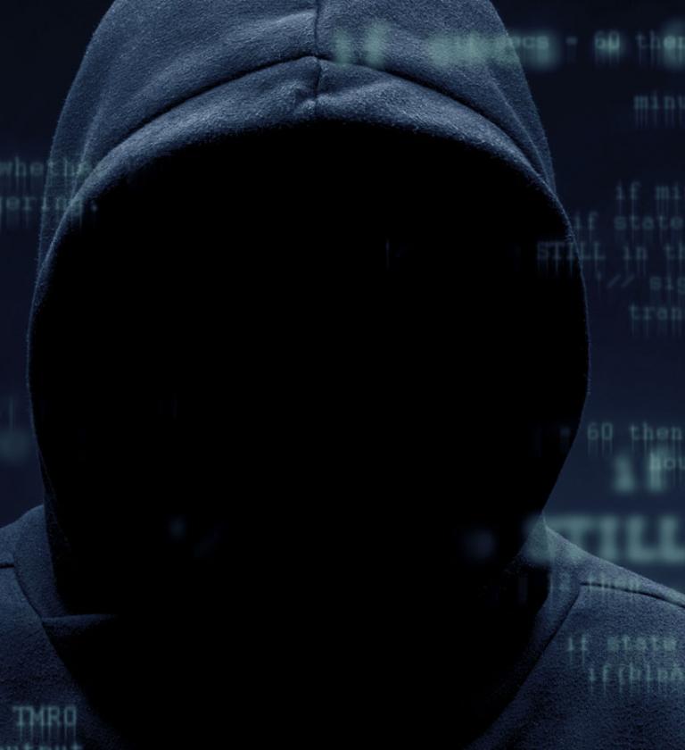 Menacing hooded figure surrounded by code