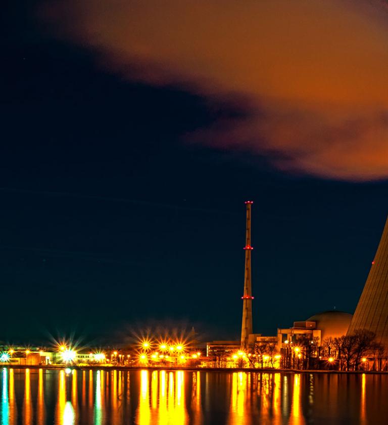 Industrial chimney blowing smoke shown at night