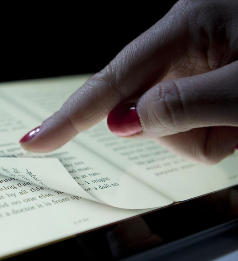 Tablet showing eBook with a finger turning the page