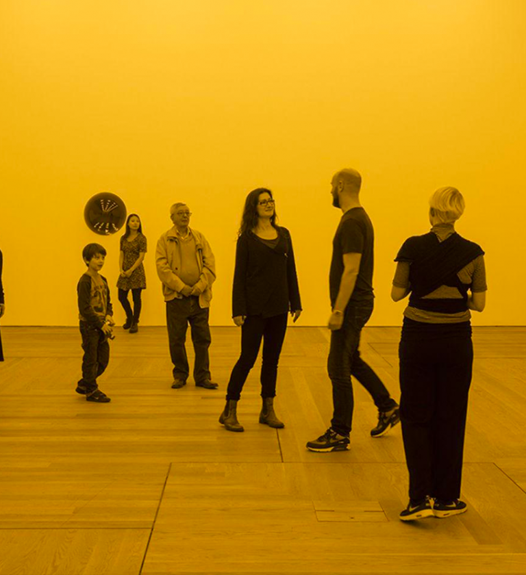 People stood in a yellow room as part of a Tate exhibition